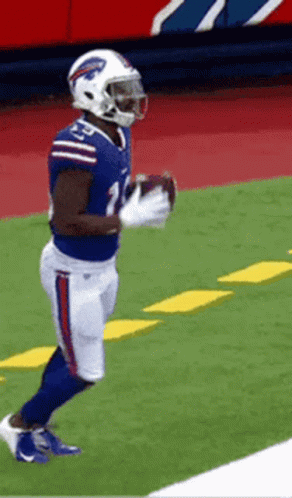 A Football Player In A Buffalo Bills Uniform Is Holding A Football GIF
