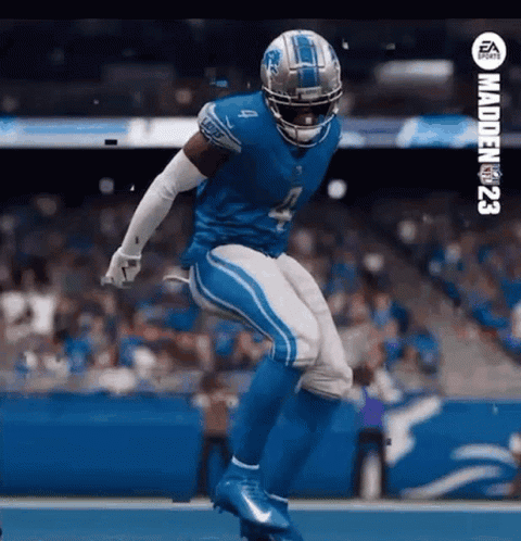 A Football Player In A Detroit Lions Uniform Is Jumping In The Air On A Field . GIF