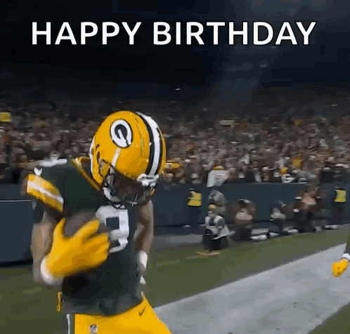 a football player in a green bay packers uniform is running with the ball .