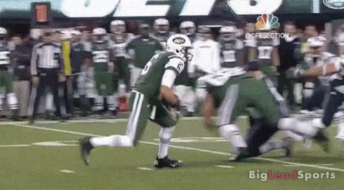 A Football Player In A Jets Uniform Is Running On The Field . GIF