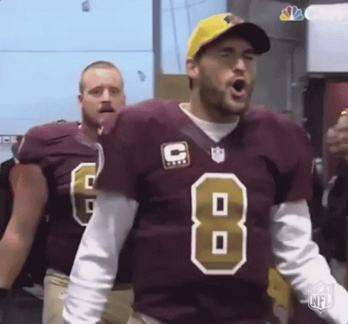 A Football Player In A Maroon Jersey With The Number 8 On It Is Standing In A Locker Room . GIF