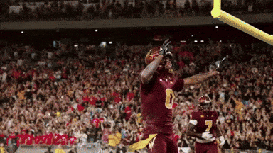 A Football Player In A Maroon Uniform With The Number 8 On His Jersey GIF