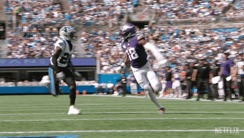 A Football Player In A Purple Uniform With The Number 12 On It GIF