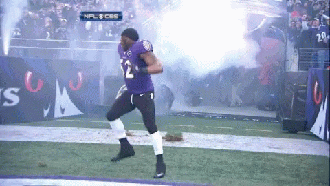 A Football Player In A Purple Uniform With The Number 12 On It GIF