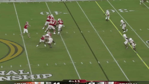 A Football Player In A Red Indiana Jersey Is Being Tackled By Another Player GIF
