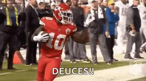 A Football Player In A Red Uniform Is Running With The Ball On The Field . GIF