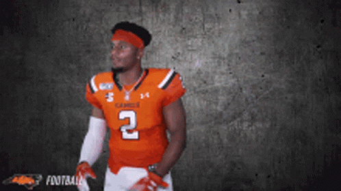 A Football Player In An Orange Jersey With The Number 2 On It GIF