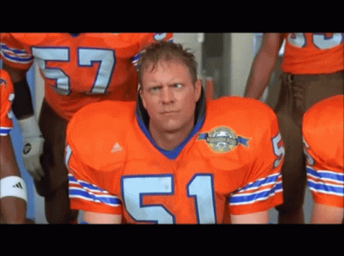 A Football Player In An Orange Jersey With The Number 51 GIF