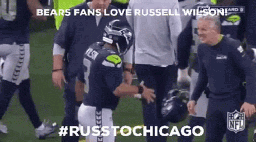 A Football Player Is Being Helped Off The Field By A Group Of Men . GIF