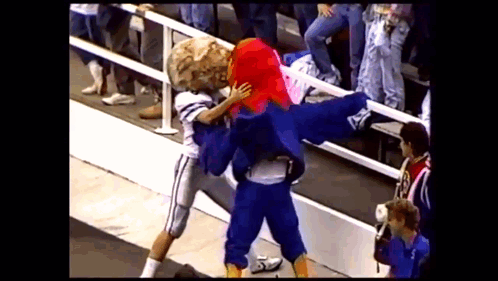 A Football Player Is Being Tackled By A Mascot That Has The Letter A On It GIF