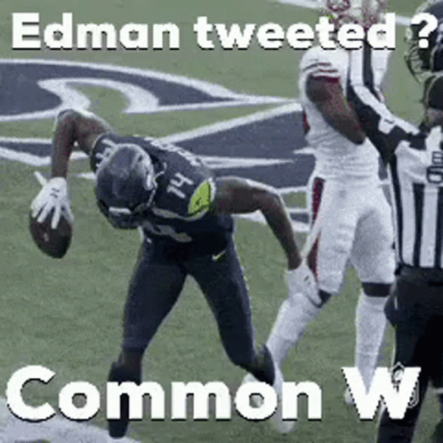 A Football Player Is Being Tackled By A Referee On A Field While Holding A Football . GIF