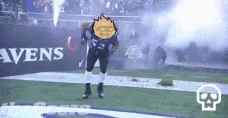A Football Player Is Dancing On The Field While A Fireworks Display Is Going On In The Background . GIF
