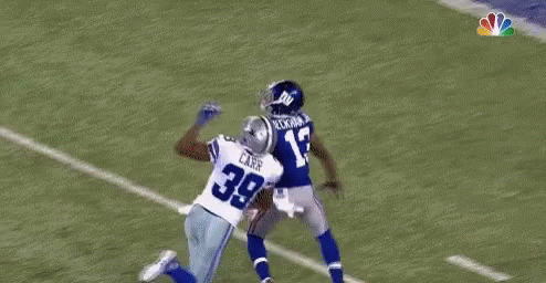 A Football Player Is Flying Through The Air While Catching A Ball . GIF