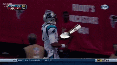 a football player is holding a trophy in front of a banner that says business