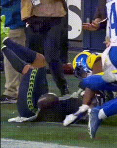 a football player is laying on the field with his knee up
