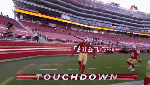 A Football Player Is Running On A Field With The Words Touchdown Written On It GIF