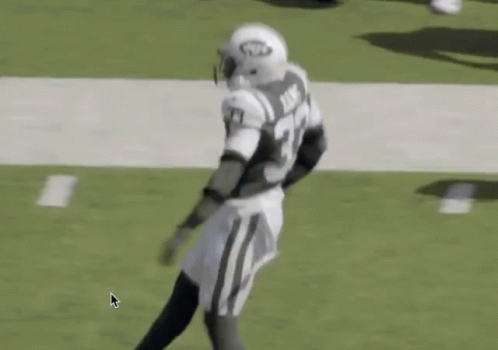 A Football Player Is Running On The Field With His Arms In The Air . GIF