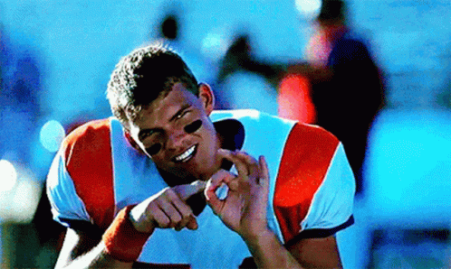 A Football Player Is Smiling And Making A Funny Face With His Hands GIF