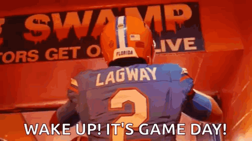 A Football Player Is Standing In Front Of A Sign That Says `` Wake Up ! It 'S Game Day '' . GIF