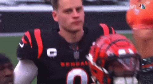 A Football Player Is Standing On A Field With His Helmet On . GIF
