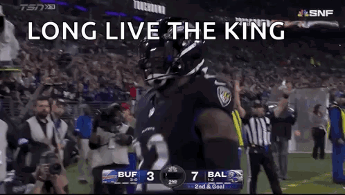 a football player is standing on a field with the words `` long live the king '' on the screen .