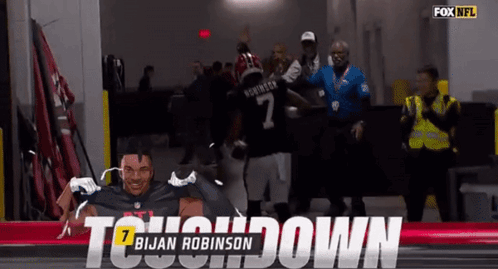 A Football Player Named Brian Robinson Is Being Congratulated GIF