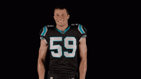 A Football Player Wearing A Black Jersey With The Number 59 On It Is Standing In Front Of A Black Background With His Ha GIF