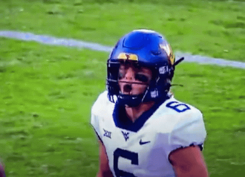 A Football Player Wearing A Blue Helmet And A White Jersey With The Number 8 On It Is Standing On A Field . GIF