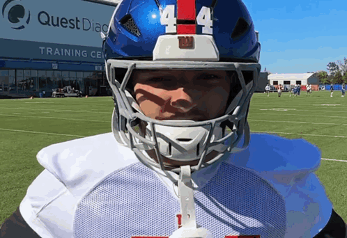A Football Player Wearing A Blue Helmet With The Number 4 On It GIF