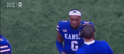 A Football Player Wearing A Blue Kansas Jersey Is Talking To A Coach . GIF