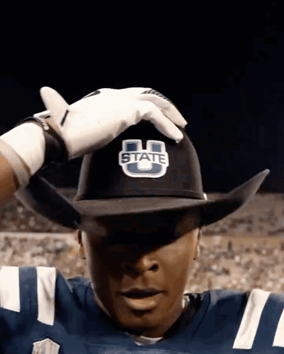 A Football Player Wearing A Cowboy Hat That Says State GIF