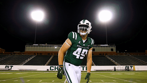 a football player wearing a green uniform with the number 49 on it