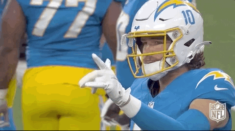 A Football Player Wearing A Helmet And Gloves Is Giving A Thumbs Up . GIF