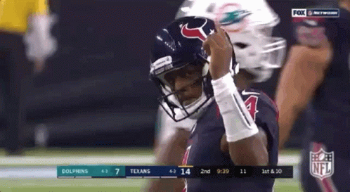 A Football Player Wearing A Helmet Is Standing On A Field . GIF