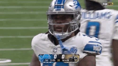 A Football Player Wearing A Helmet Stands On A Field With A Scoreboard Displaying The Score Of 0 To 39 GIF