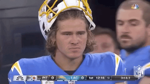 A Football Player Wearing A Helmet Stands On The Sidelines GIF