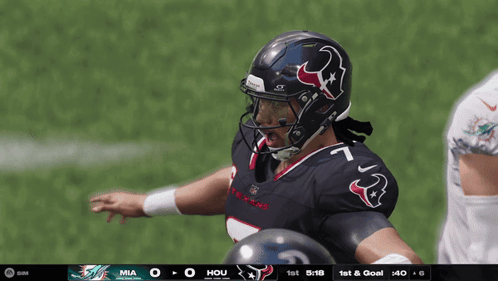 A Football Player Wearing A Helmet With A Bull On It Stands On The Field GIF
