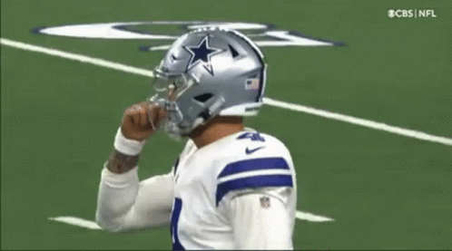 A Football Player Wearing A Helmet With A Star On It Is On The Field . GIF