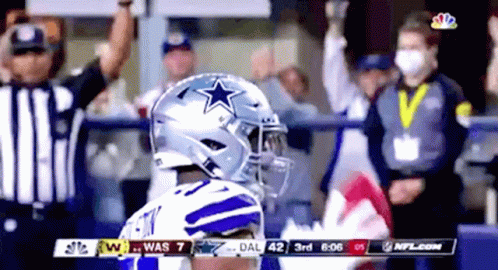 A Football Player Wearing A Helmet With A Star On It Stands In Front Of A Crowd During A Game . GIF