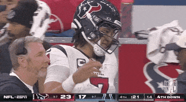 A Football Player Wearing A Helmet With The Number 7 On It Stands In The Stands GIF