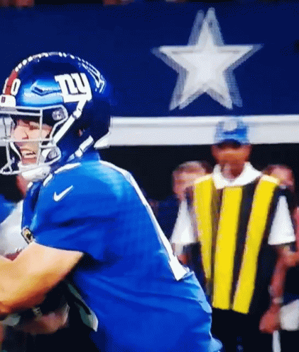 A Football Player Wearing A Helmet With The Ny Giants Logo On It GIF