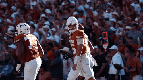 a football player wearing a jersey that says texas stands in front of a crowd