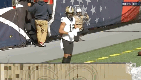 A Football Player Wearing A Jersey With The Number 12 On It Is Standing On The Field . GIF