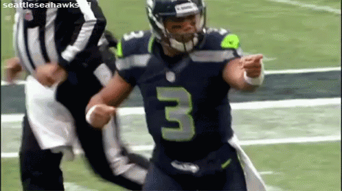A Football Player Wearing A Jersey With The Number 3 On It Is Running On A Field . GIF