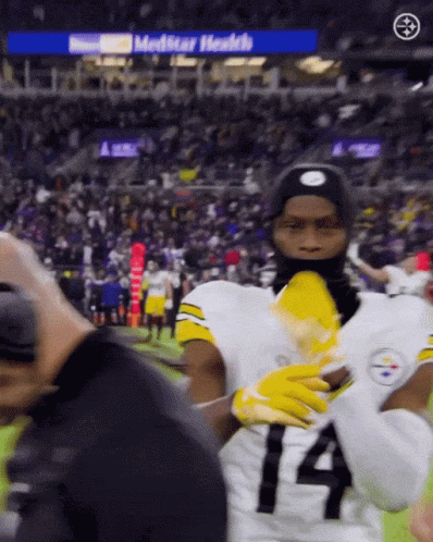 A Football Player Wearing A Number 14 Jersey Stands On The Field GIF
