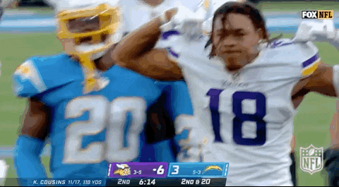 A Football Player Wearing A Number 18 Jersey Stands Next To Another Player GIF