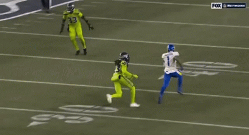 A Football Player Wearing A Number 23 Jersey Is Running On The Field . GIF