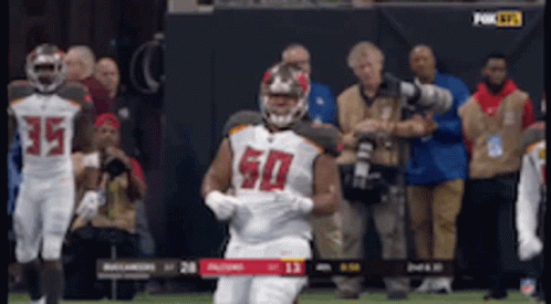 A Football Player Wearing A Number 50 Jersey Is Running On The Field GIF