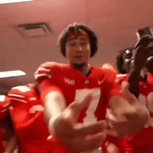 A Football Player Wearing A Number 7 Jersey Is Hugging Another Player . GIF