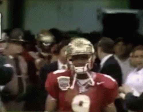 a football player wearing a number 8 jersey stands in a crowd